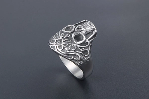 Close-up of vintage punk skull ring with gothic patterns and oxidized steel finish