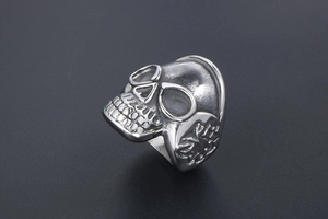 Close-up of vintage stainless steel skull ring with distressed finish and ornate side patterns
