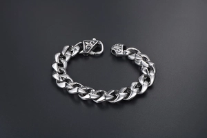 Gros plan sur un bracelet gourmette en acier titane argenté avec fermoir fleur de lys