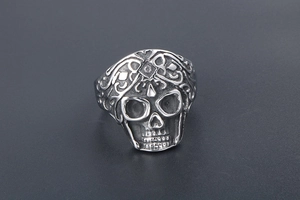 Close-up of retro punk skull ring with intricate floral carvings in silver-tone titanium
