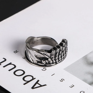 Detailed close-up of vintage titanium steel angel wing ring with carved relief texture