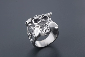 Detailed 45-degree angle view of vintage silver skull ring with Jolly Roger engraving