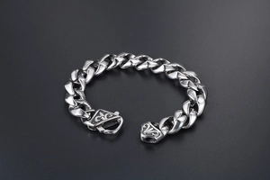 Gros plan du bracelet gourmette en acier titane argenté avec gravure de fleur de lys