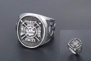 Macro view of vintage stainless steel signet ring with crown and Latin cross-swords design