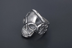 Macro view of vintage skull ring showing detailed relief and matte stainless steel finish