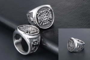 Detailed close-up of retro stainless steel signet ring with Latin inscription and cross