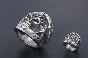 Detail of vintage steel ring featuring embossed skull and starfish gothic patterns