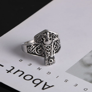 Macro detail of Mjolnir ring with Celtic knotwork and viking skull carving in steel