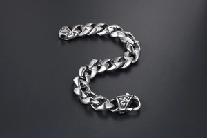 Gros plan d'un bracelet gourmette en acier titane argenté avec détails gravés vintage