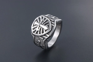 Dettaglio macro dell'anello a sigillo vintage con croce incisa e finitura argento opaco