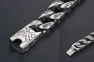 Macro detail of punk style stainless steel bracelet with engraved Buddhist scripture