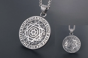 Dettaglio del ciondolo tondo in acciaio al titanio argento vintage con stella e rune incise
