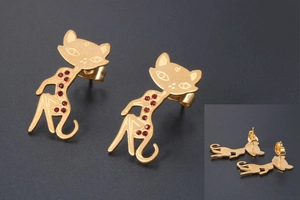Detailed view of rose gold cat stud earrings featuring sparkling red crystals on matte background