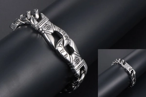Macro detail of punk stainless steel bracelet with engraved Buddhist script characters
