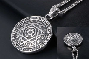 Dettaglio del ciondolo a stella vintage con rune e catena in acciaio intrecciato