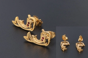 Close-up of 18K gold-plated dolphin stud earrings with small red zircon stones