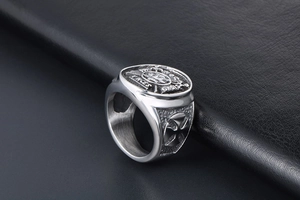 Macro side view of vintage steel ring featuring a cross emblem and Latin engraving