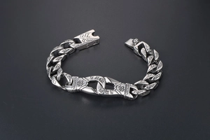 Macro detail of punk titanium steel bracelet with engraved Buddha character and motifs