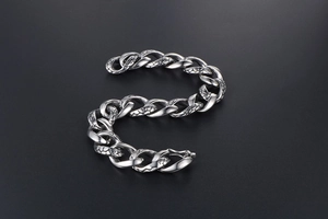 Macro shot of silver titanium steel chain bracelet with detailed snake scale texture links