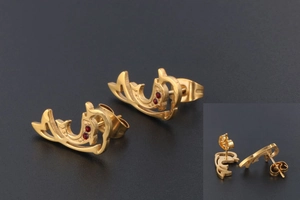 Detail view of gold dolphin stud earrings with deep red zircon stones and butterfly back