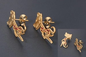 Detailed view of rose gold cat stud earrings featuring vibrant red crystal accents