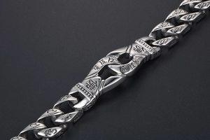 Macro view of punk stainless steel chain bracelet with engraved Buddhist characters