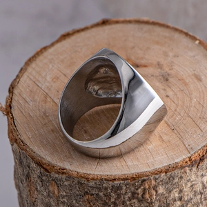 Minimalist silver titanium steel ring with unique textured surface for men on wood base