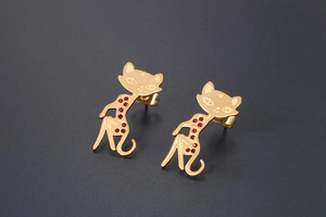 Close-up of cat-shaped rose gold stud earrings with sparkling red rhinestone accents