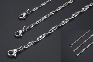 Detail of silver water wave chain necklace with lobster clasp and metal texture on dark background