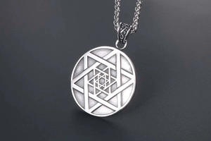 Gros plan du pendentif étoile à six branches avec sa chaîne en maille épi détaillée