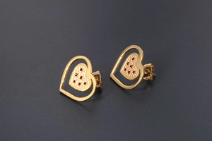Detailed macro view of 18K gold-plated heart earrings with red crystal inlay