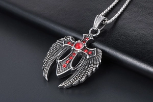 Makroaufnahme von gotischem Adler-Kreuz-Anhänger mit roten Strasssteinen auf schwarzem Leder