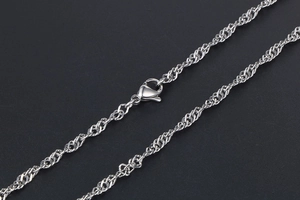Macro shot of silver water wave chain necklace with a classic metal lobster clasp