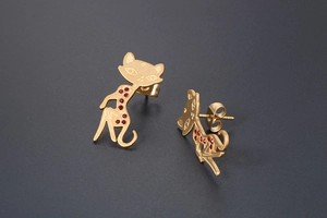 Macro shot of rose gold cat earrings with red rhinestones on a black background