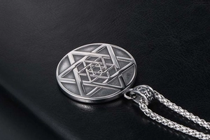 Macro d'un collier en acier titane argenté avec motif de relief étoile hexagonale détaillé