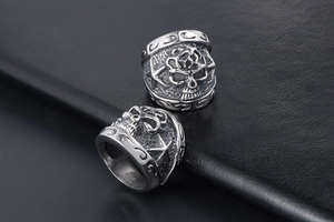 Detail of vintage skull and star embossed stainless steel punk rings on black leather