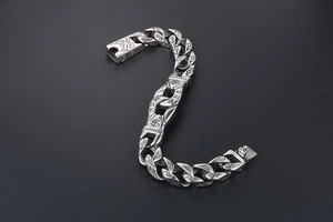 Detailed macro view of vintage silver steel Cuban chain with religious symbols