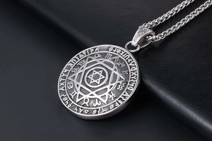 Dettaglio del ciondolo esagramma vintage in argento con incisione gotica su pelle nera