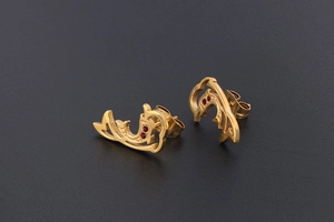Macro shot of 18K gold plated dolphin earrings with sparkling red rhinestone accents