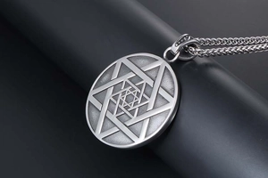 Détail macro du collier en acier titane argenté avec pendentif étoile à six branches
