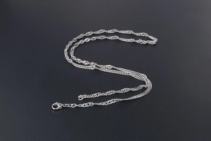 Detailed macro view of the silver water wave chain with a secure lobster clasp closure