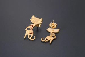 Detailed macro view of gold cat stud earrings featuring five sparkling red crystals
