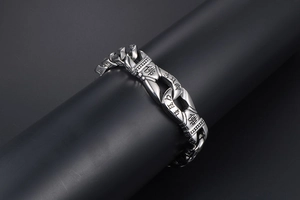 Macro view of punk stainless steel curb chain bracelet with Buddha and Sanskrit engravings