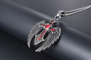 Detailansicht eines Adlerflügel-Anhängers mit rotem Zirkon-Schwert und Box-Kette
