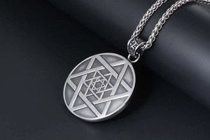Vue macro d'un collier en acier titane vintage montrant la gravure détaillée de l'hexagramme