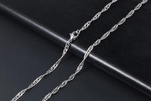 Macro shot of silver water wave chain necklace with lobster clasp on black leather