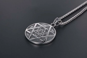 Gros plan d'un pendentif hexagramme vintage en acier titane avec motifs gravés