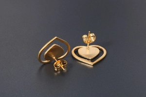 Detail view of gold-plated double heart stud earrings with secure butterfly backs