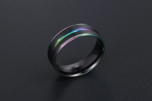 Vue macro d'une bague en titane noir mat avec rainure centrale arc-en-ciel éclatante