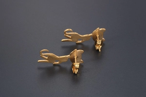 Macro shot of rose gold cat-shaped stud earrings featuring a delicate brushed metal finish